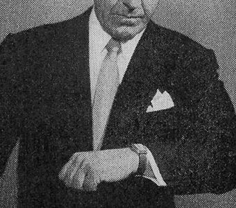 縦長の腕時計を確認する男性