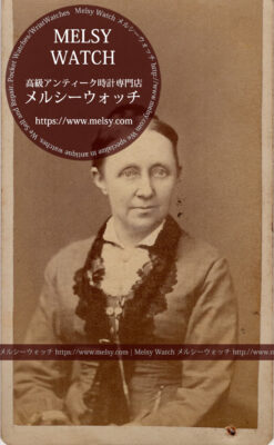 ネックレスから腰のポケットに懐中時計を収めている女性の写真 【1900年頃】-I4080