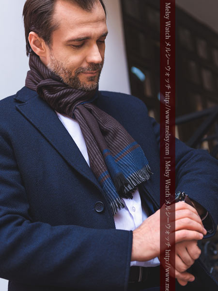 マフラーとコートを羽織る紳士と腕時計