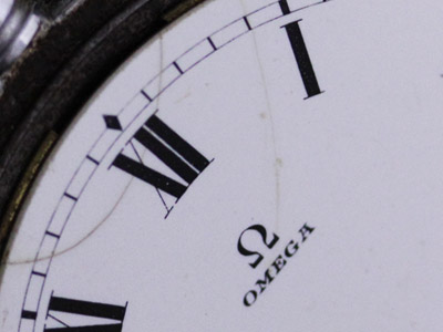 ヒビが数か所入った陶製の文字盤