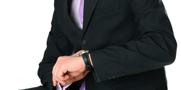 腕時計を見るスーツ姿の男性